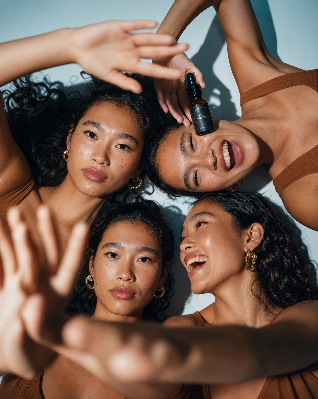 Four radiant women together, holding the Anis Brows serum